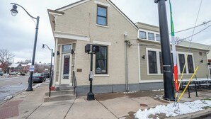 Ein Gebäude mit einer beige farbenen Fassade, einem sichtbaren Schaufenster und einem mit Schnee bedeckten Bürgersteig.