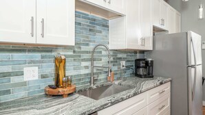 A kitchen with white cabinets, a stainless steel sink, and a coffee maker. - Findlay Market Suite 3 – For 2! (Cincinnati)