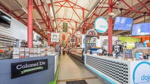 A food court with a Colonial De sign, a dojo sign, and a menu board. - Findlay Market Suite 3 – For 2! (Cincinnati)