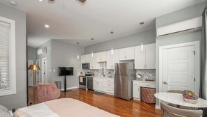 A modern kitchen with white cabinets, stainless steel appliances, and pendant lighting. - Findlay Market Suite 5 – For 2! (Cincinnati)