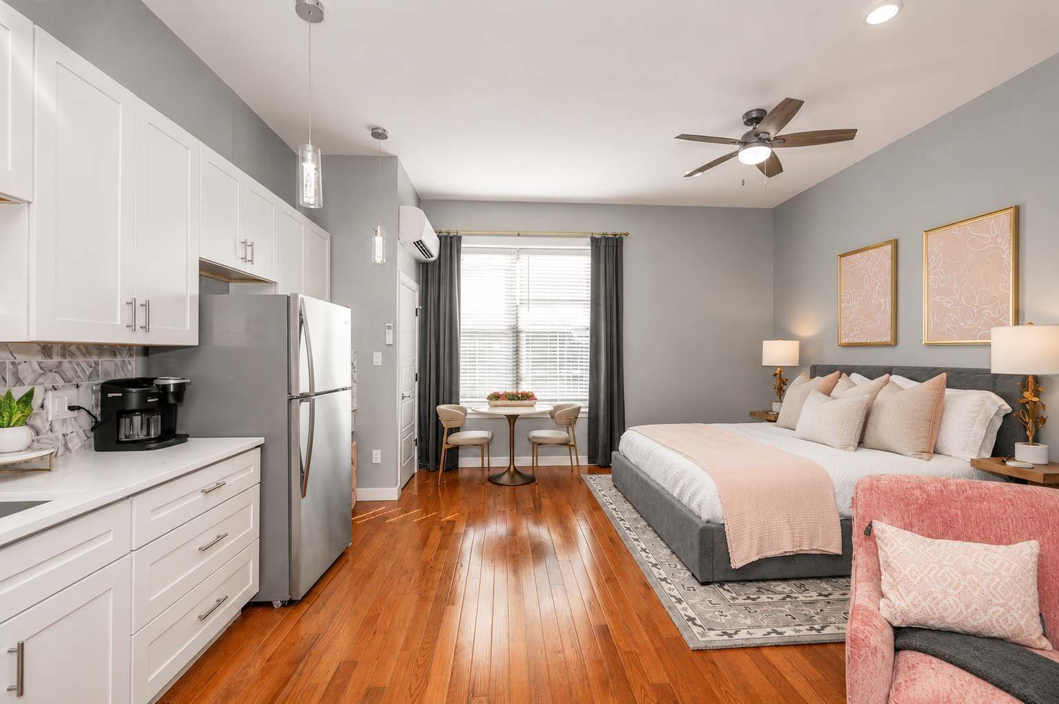 A modern bedroom with a bed, bedside tables, and a ceiling fan.