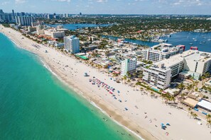 Ein Hotel an der Küste mit mehreren Gebäuden, einem Strand und einer Marina.