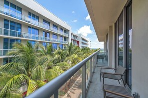 Ein Balkon mit Blick auf ein modernes Gebäude und Palmen.