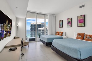 A modern hotel room with two beds, a desk, and a large window with a city view.