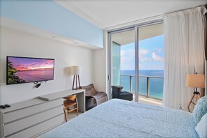 A hotel room with a bed, a desk, a chair, a TV, and a balcony with a view of the sea. - Stunning  Penthouse  Resort Amenities  12 people (Hollywood)