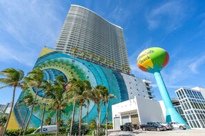 A tall hotel with a colorful mural and a large inflatable beach ball.