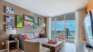 Una sala de estar moderna con un sofá, un sillón, una mesa de centro y una obra de arte en la pared.