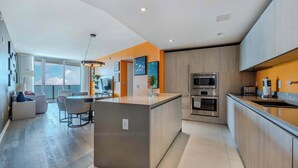 Una cocina moderna con una isla central, electrodomésticos integrados y un comedor con vistas.