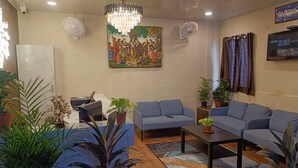Una sala de estar moderna con sofás azules, una mesa de centro y plantas decorativas.