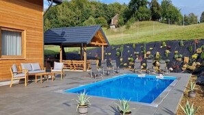 A wooden cabin with a swimming pool, outdoor seating, and a garden area. - Holiday Home Wiśniowa with Pool and Mountains (Iwierzyce)
