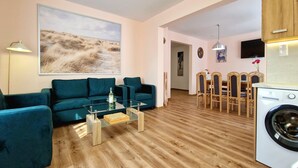 A modern living room with a sofa, coffee table, and a painting on the wall. - Holiday Home Wiśniowa with Pool and Mountains (Iwierzyce)