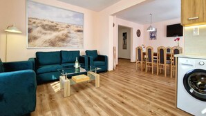 A modern living room with a sofa, coffee table, and a painting on the wall. - Holiday Home Wiśniowa with Pool and Mountain Views (Iwierzyce)
