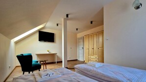 A bedroom with two beds, a desk, a chair, a TV, and a wardrobe. - Holiday Home Wiśniowa with Pool and Mountain Views (Iwierzyce)