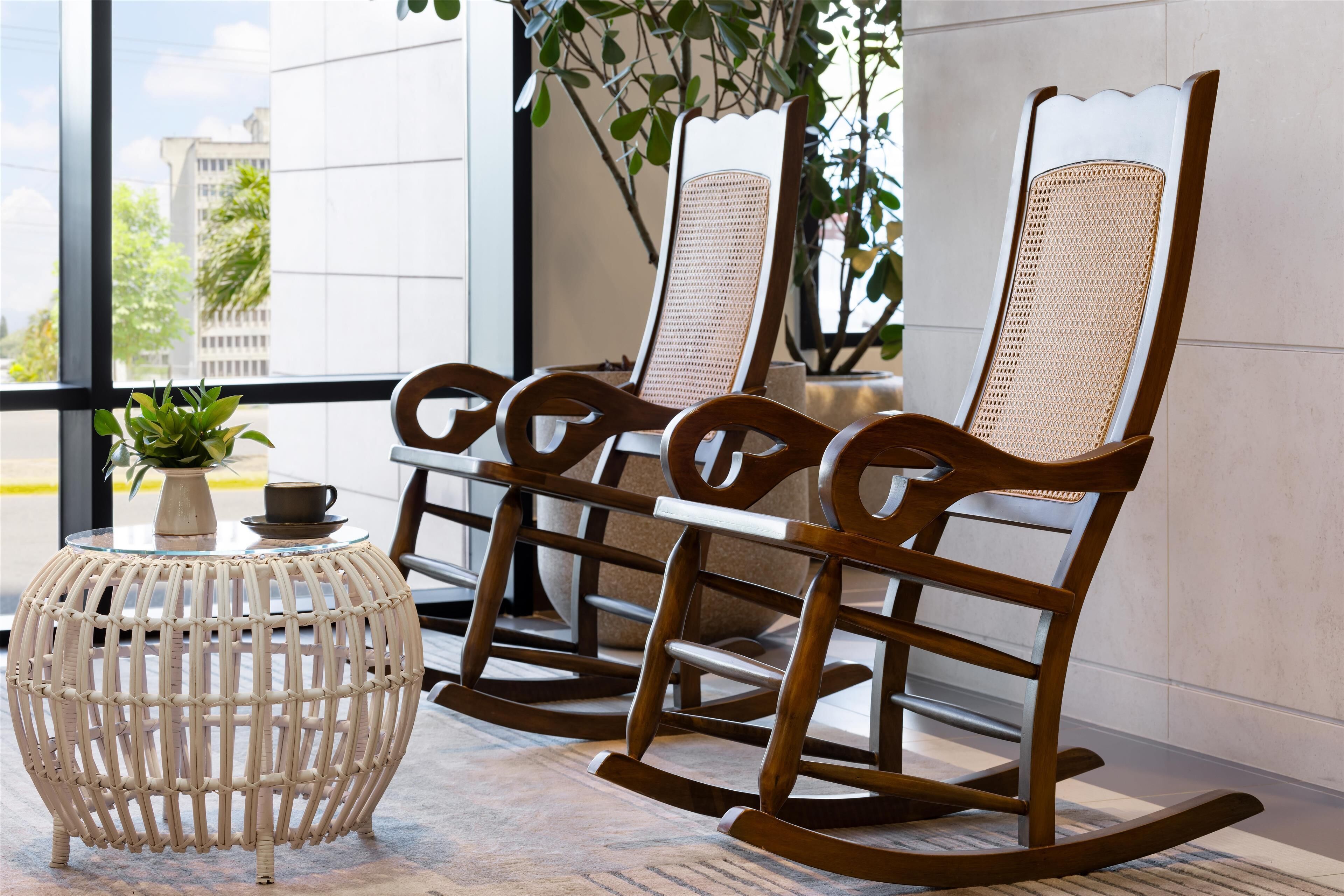 A modern interior with a glass table, wicker chairs, and a round wicker side table.