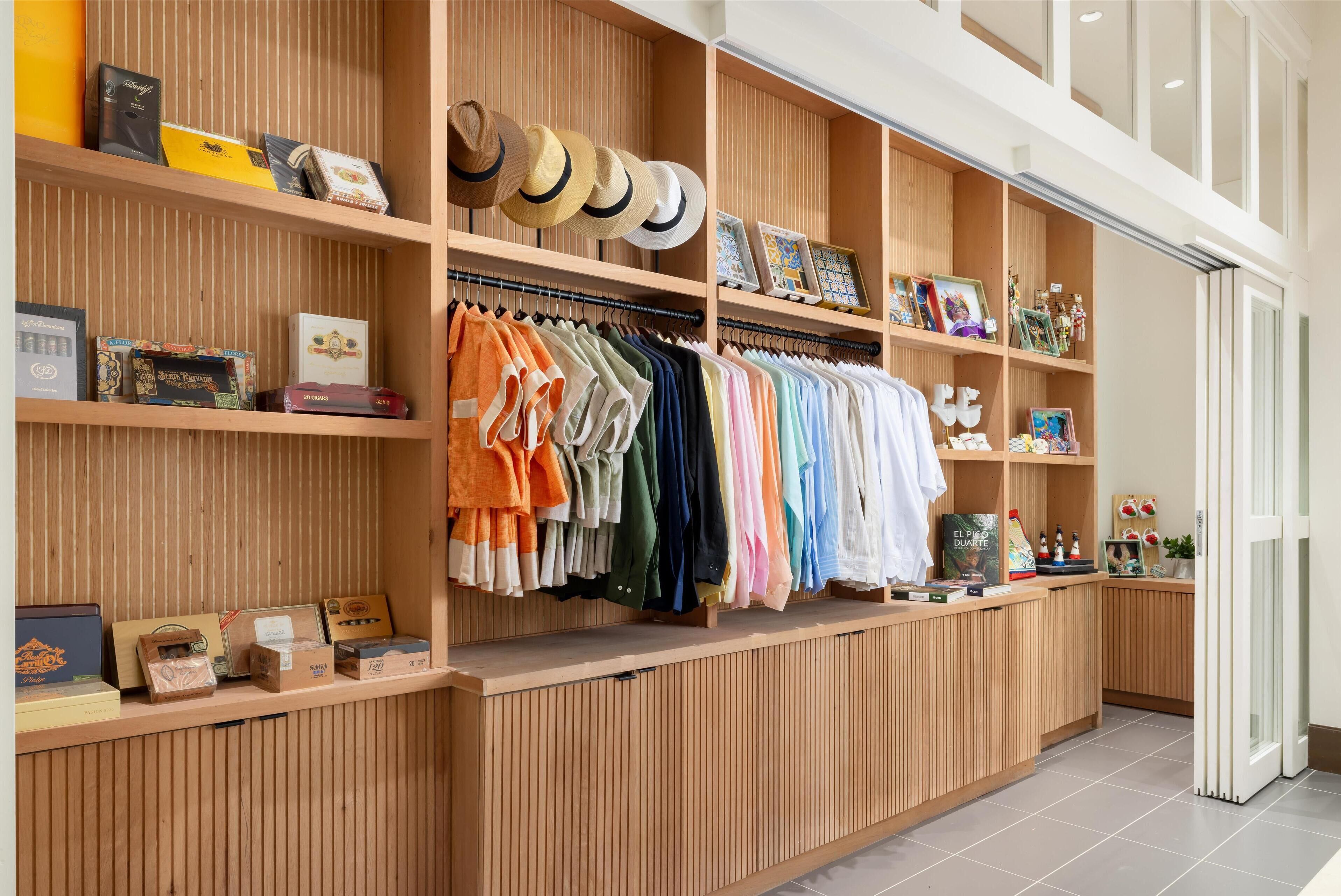A clothing store with wooden shelves displaying hats, shirts, and accessories.