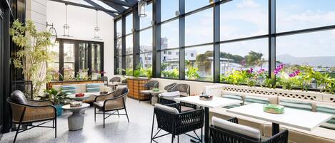 A modern outdoor seating area with wicker furniture, a white table, and potted plants.