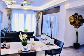 Ein modernes Wohnzimmer mit einer Couch, einem Esstisch und Wanddekoration.