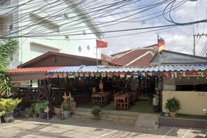 A building with a tiled roof, a flag, and outdoor seating. - Yunman Vacation Villa Pattaya (Pattaya)