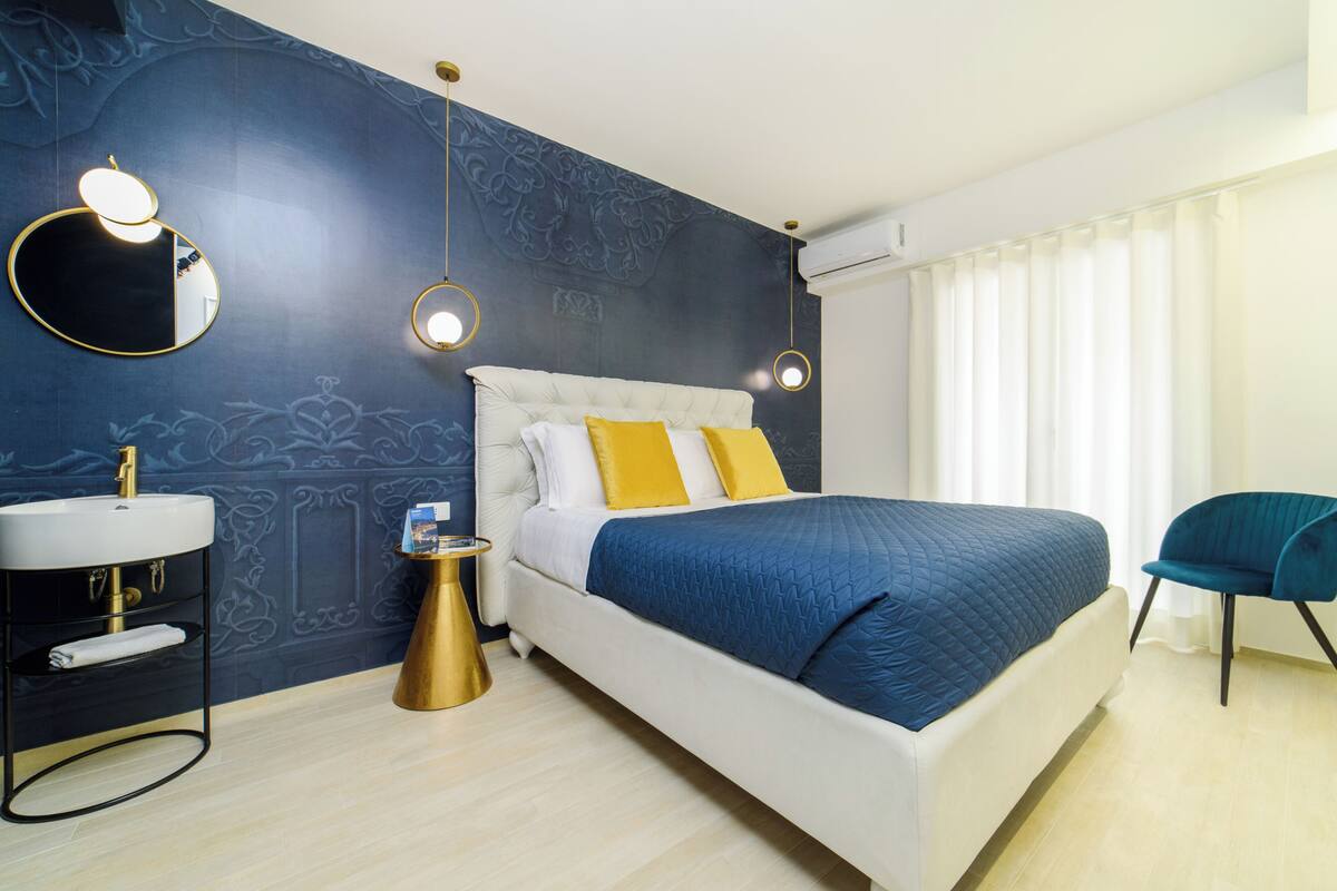 Quarto com cama, mesa de cabeceira e espelho.