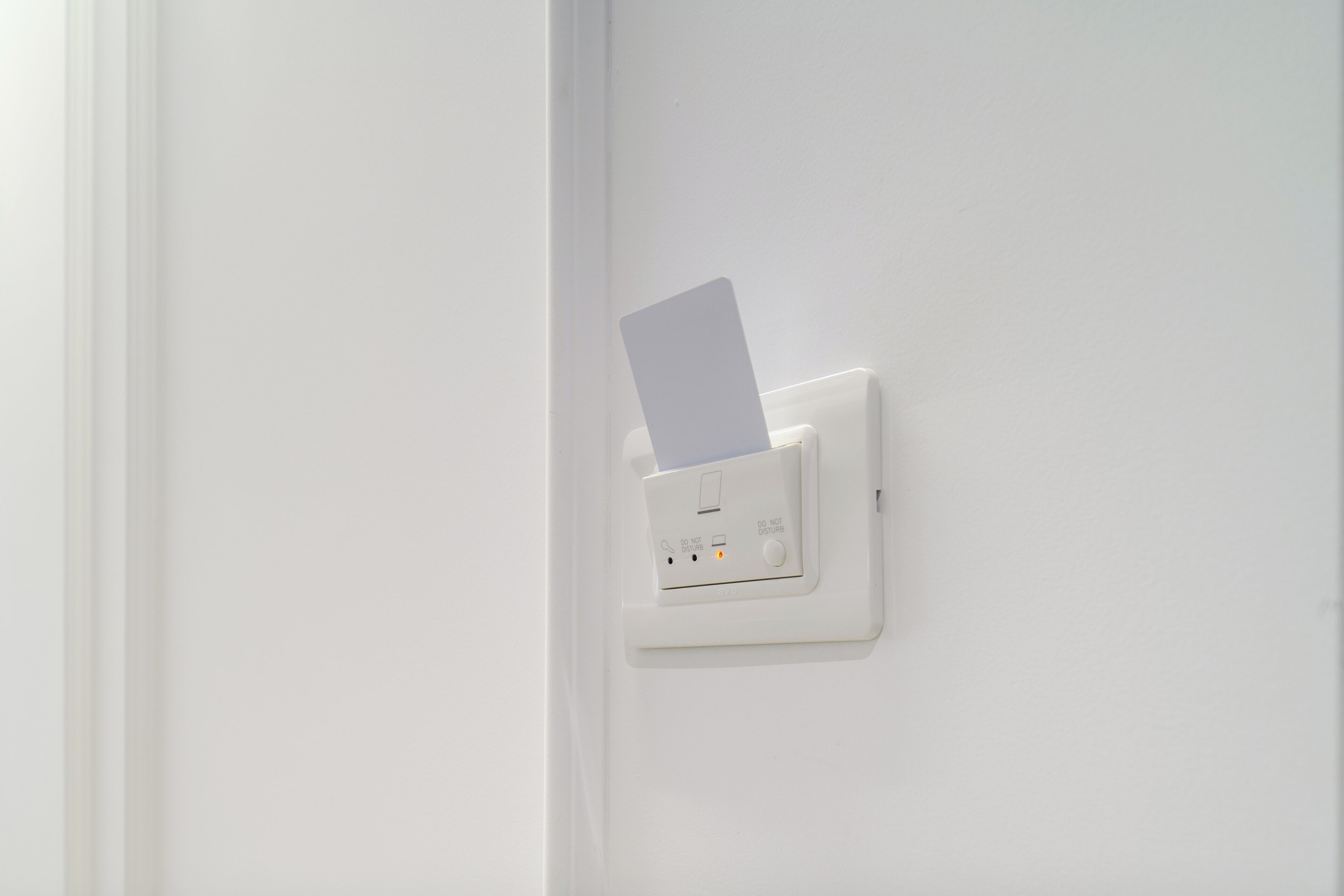 A white electrical outlet with a card inserted into it.