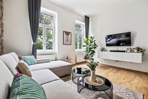 Un salon moderne avec un canapé, une table basse et un téléviseur fixé au mur.