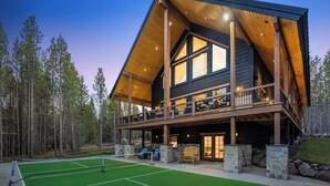 A large wooden cabin with a balcony, a tennis court, and stone walls. - Midnight Pines Lodge+HotTub+Cent AC+20mYellowstone (Island Park)