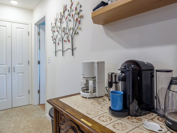 Una cocina con cafetera, tostadora y un adorno de pared.