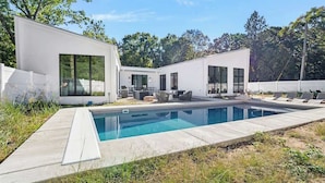 A modern house with a swimming pool, outdoor seating, and a white fence. - Juniper Presents: Fab Vacay Home, Pool, Walk to Lake Michigan Beach (Michigan City)