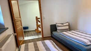 Un dormitorio con una cama, una mesita y una silla.