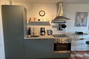 Cafetera o tetera, frigorífico, horno y placa de cocina