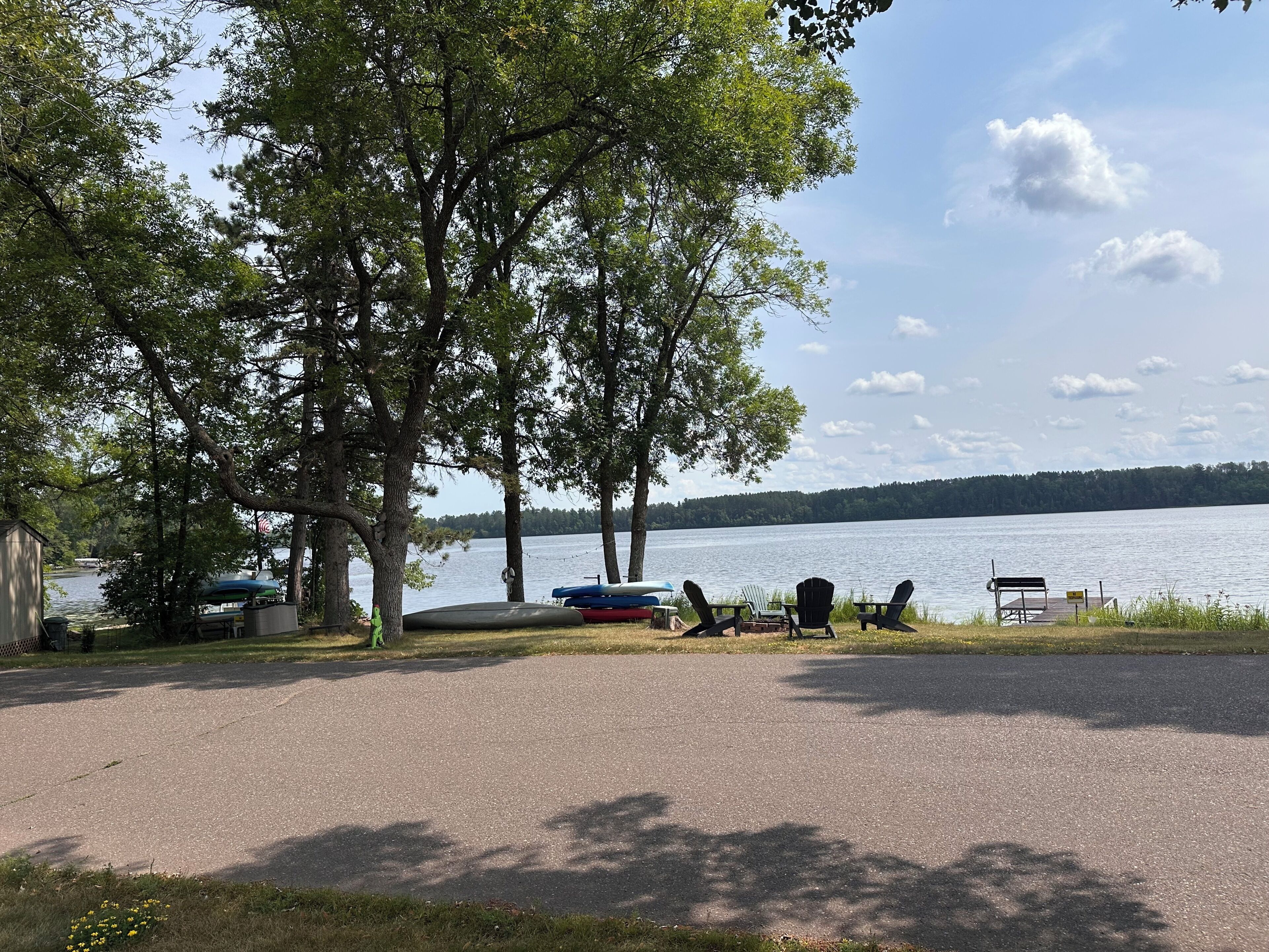 Un espace de pique-nique au bord du lac, doté d’une promenade pavée, de tables et de chaises de pique-nique.