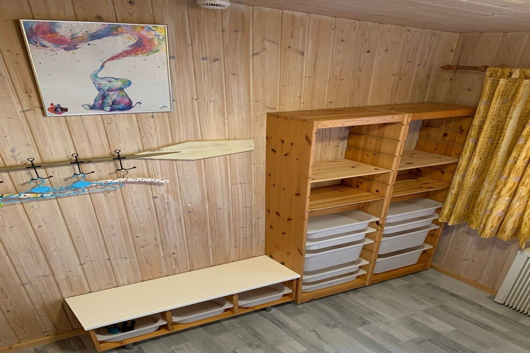 A wooden room with a shelf, a bench, and a wall-mounted rack.