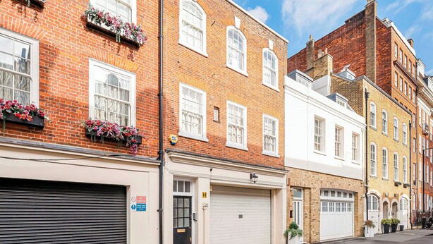 A row of traditional brick buildings with white-framed windows and flower boxes.
