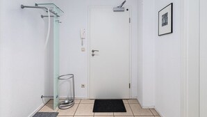 A small, clean bathroom with a glass shower enclosure, a white door, and a black doormat. - Appartement im Ferienpark in Rechlin (Rechlin)