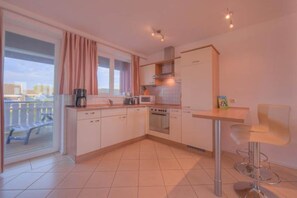 Enjoy cooking in this well-equipped kitchen with a range, microwave, and oven, and step out to a balcony with a view.