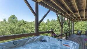 Un bain à remous sur une terrasse en bois, avec vue sur les arbres.