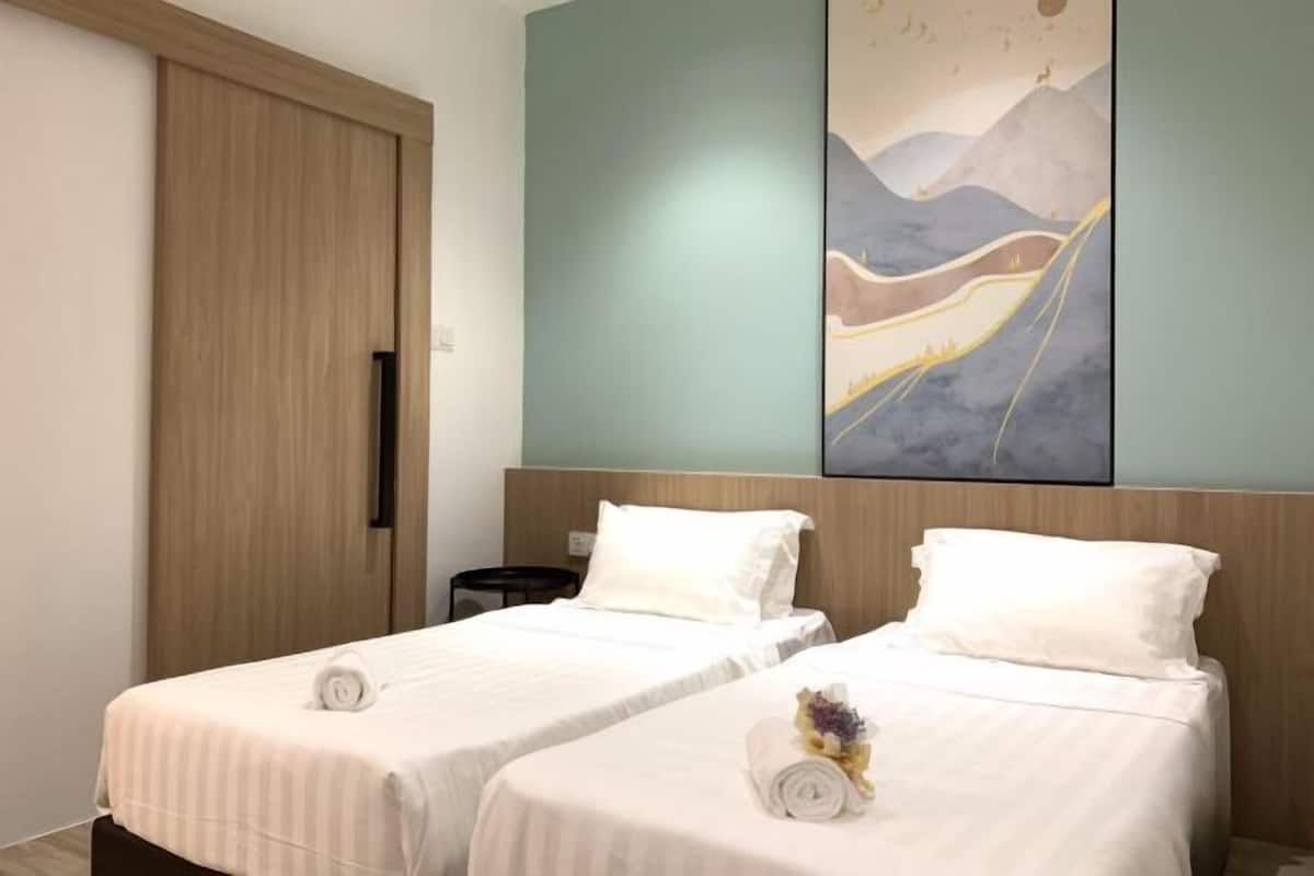 Una habitación de hotel con dos camas, un armario de madera y un cuadro abstracto grande en la pared.
