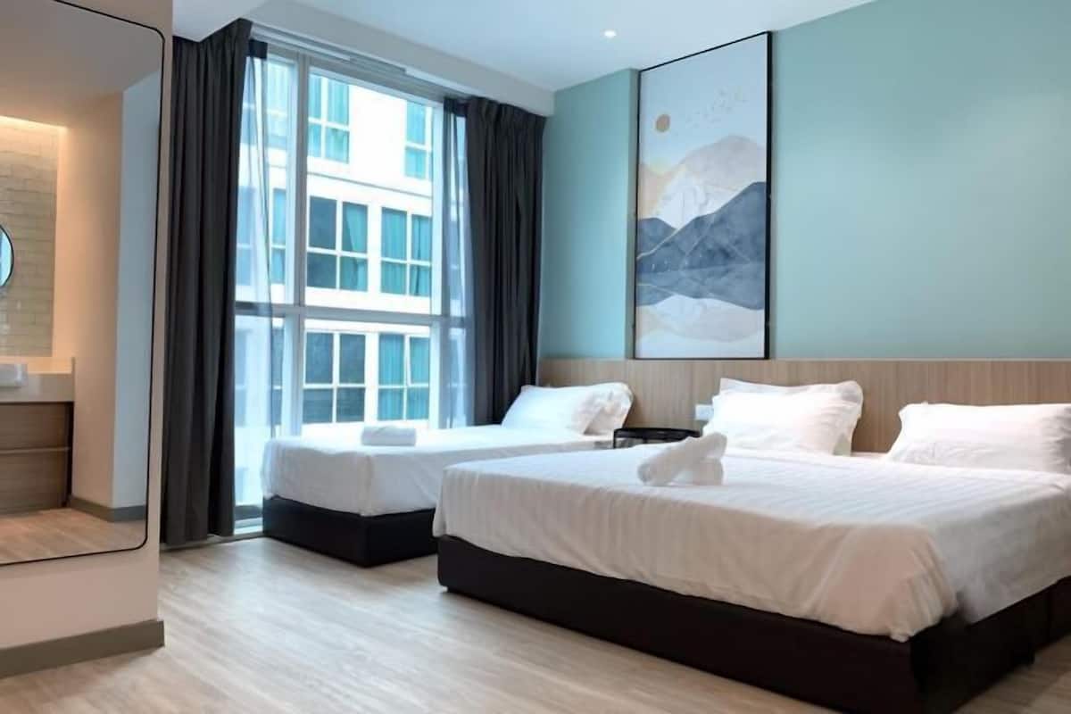 Habitación de hotel con dos camas, un ventanal grande y un cuadro abstracto moderno en la pared.