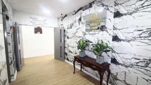 A hallway with marble walls, a wooden floor, and a sign indicating the location of flats 301-312. - Flat 308 One bedroom Apartment (Smethwick)
