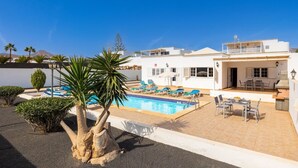 Une villa moderne dotée d’une piscine, d’un espace extérieur aménagé et offrant une vue sur les montagnes.