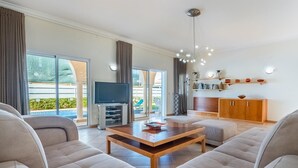 Una sala de estar moderna con televisor, sofá y una mesa de centro de madera.