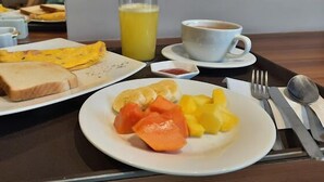 A breakfast tray with toast, an omelette, and fruit on a table. - ALBURA HOTEL (Pereira)