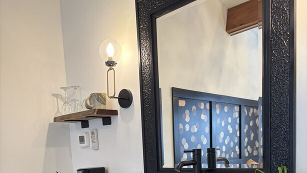 A modern bathroom with a white sink, dark countertop, and a large mirror with an ornate frame. - The Lincoln Boutique Motel- Upper Deluxe King #12 (Ellicottville)