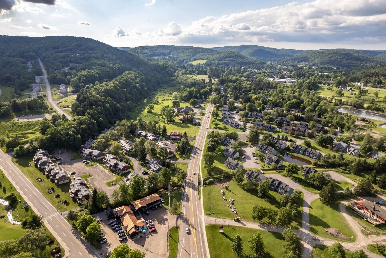 An aerial view of a residential area with houses, roads, and a river.