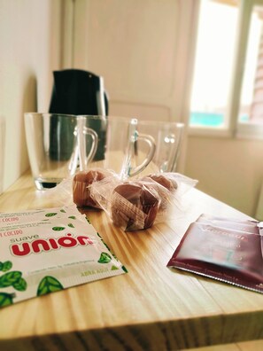 Una mesa de madera con un vaso de vidrio, una bolsa de plástico y un folleto.