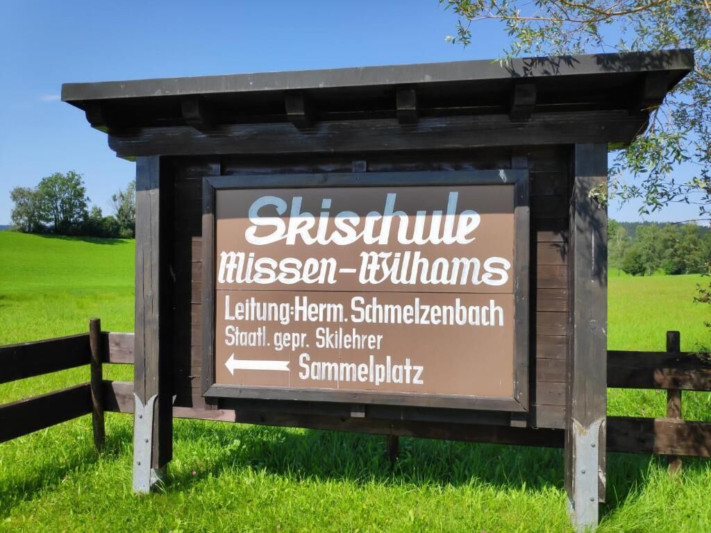 Wegwijzer naar Skischule, Miesen-Bilhams, met vermelding van locaties zoals Leitung-Herm. Schmelzenbach en Sammelplatz.