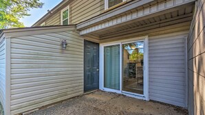Une maison dotée d’un patio couvert, d’un garage et d’une porte-fenêtre coulissante.