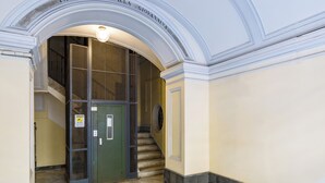 A marble-floored corridor with an arched entrance leading to a staircase.