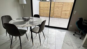 A dining area with a table and chairs, a floor lamp, and a view through a sliding door to an outdoor space. - House in Creteil near Paris (creteil)