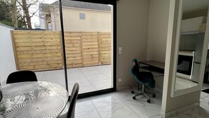 A modern living room with a glass door leading to a balcony, a dining table with chairs, and a teal office chair. - House in Creteil near Paris (creteil)